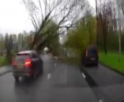 Terrifying dashcam footage shows the moment a huge tree fell just feet from passing motorists - after high winds caused carnage across Britain.&#60;br/&#62;&#60;br/&#62;The shocking video revealed how drivers had to slam on their brakes as the roughly 45ft (14m) tall oak came crashing down during a storm yesterday (Mon 15).&#60;br/&#62;&#60;br/&#62;Filmmaker Matt Jones was heading along Princess Road, in Manchester, when he captured the massive tree topple over and smash into the road just after noon.&#60;br/&#62;&#60;br/&#62;Writing in a post on social media, the shocked director later said: “That was a close one”.&#60;br/&#62;&#60;br/&#62;The footage showed how the tree collided with a van in the outside lane of the carriageway, while another car narrowly avoided a collision.&#60;br/&#62;&#60;br/&#62;But thankfully Matt managed to hit his brakes in time to prevent any serious damage to him or his vehicle. &#60;br/&#62;&#60;br/&#62;Met Office data shows how Manchester experienced gusts of up to 45mph yesterday before residents later witnessed thunder, lightning, heavy rain and then hail.&#60;br/&#62;&#60;br/&#62;The wintry conditions had caused the service to issue a yellow weather warning for the whole country.&#60;br/&#62;&#60;br/&#62;And there were even reports of a tornado hitting Newcastle-under-Lyme, Staffordshire, with pictures showing damaged rooves and overturned campervans.&#60;br/&#62;&#60;br/&#62;However, after enduring the longest period of wet weather in British history, the Met Office has now said there is some good news on the horizon for the country. &#60;br/&#62;&#60;br/&#62;The service said by the weekend, some parts will see an uptick in temperatures as high pressure moves in from across the Atlantic.&#60;br/&#62;&#60;br/&#62;Deputy Chief Meteorologist Mark Sidaway said: “Don’t expect a heatwave. &#60;br/&#62;&#60;br/&#62;&#92;